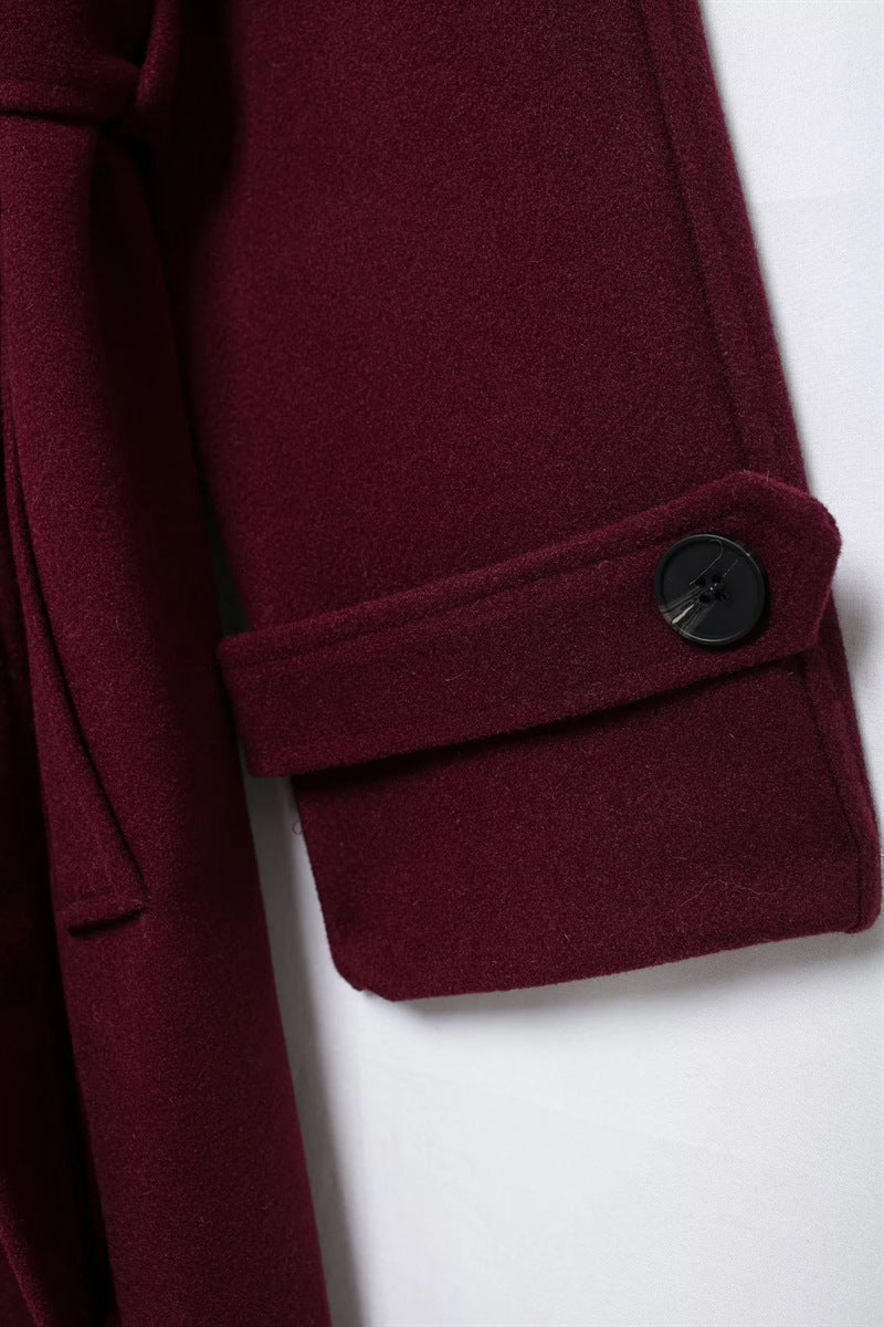 Elegant burgundy vinterjacka med dubbelknappar och bälte.