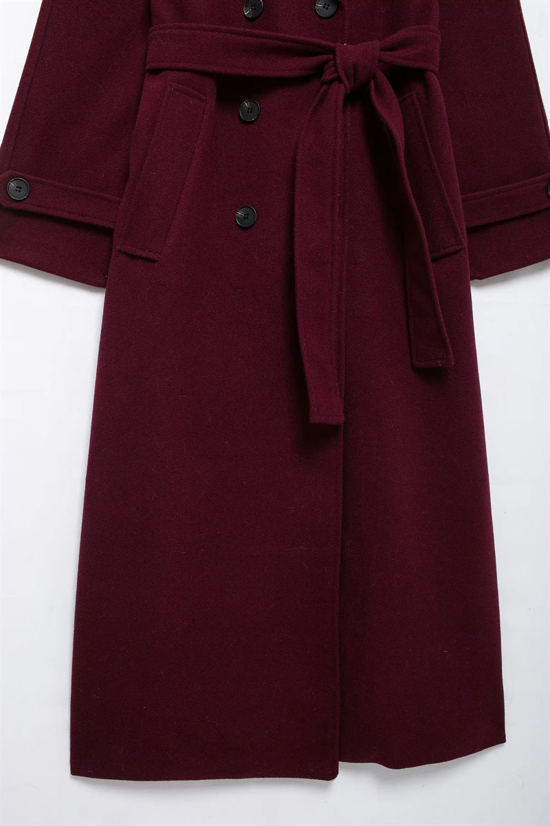 Elegant burgundy vinterjacka med dubbelknappar och bälte.