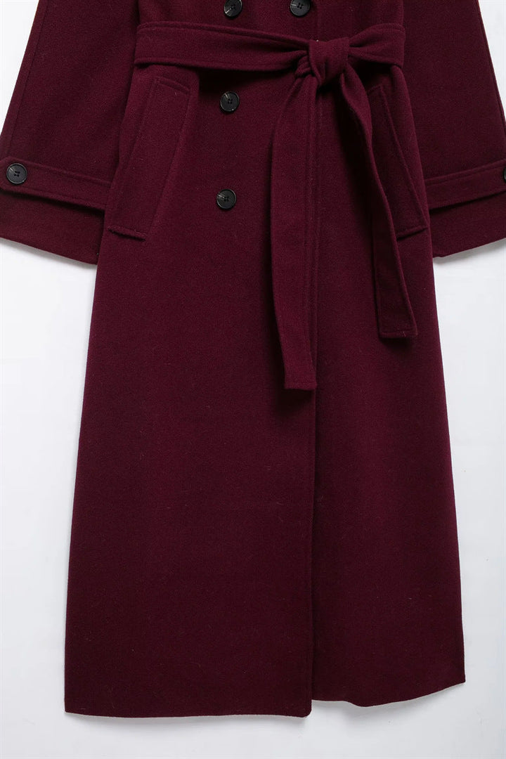 Elegant burgundy vinterjacka med dubbelknappar och bälte.